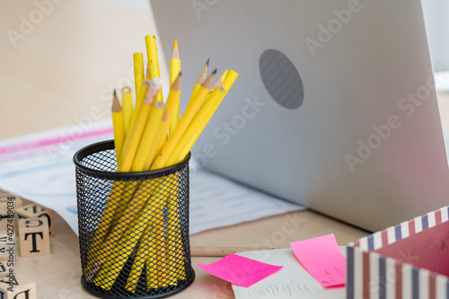 Close up on table in the office that mess up with stationery and laptop for working