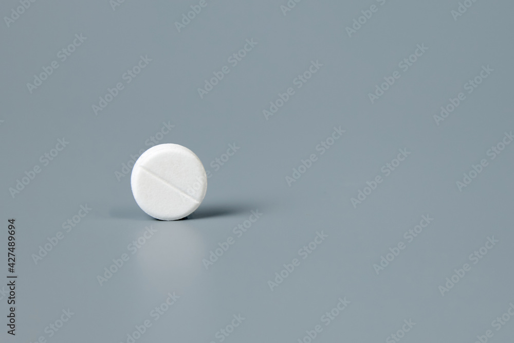 Round white pill on a gray background. High quality photo Round white pill on a gray background. High quality photo