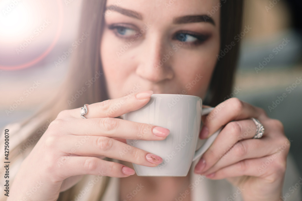Young woman in white jacket working in cafe with papers, drinking coffee Young woman in white jacket working in cafe with papers, drinking coffee