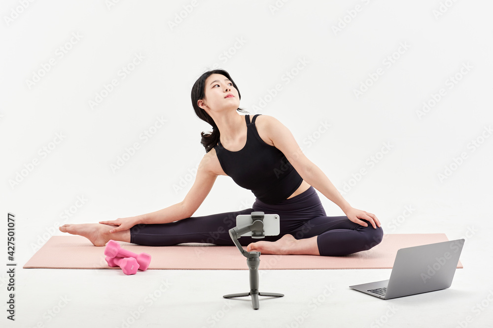 Asia Korean Girl training at white background , watching videos on laptop, and live streaming using gimbal in sns Asia Korean Girl training at white background , watching videos on laptop, and live streaming using gimbal in sns