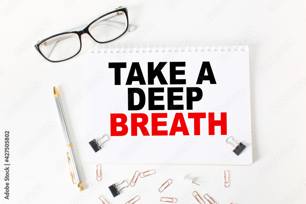 Notepad with inscriptions TAKE A DEEP BREATH on a white background. business concept. Notepad with inscriptions TAKE A DEEP BREATH on a white background. business concept.