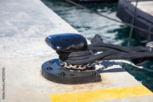 Boat ropes on black mooring bollard  luxury yachts marina pier