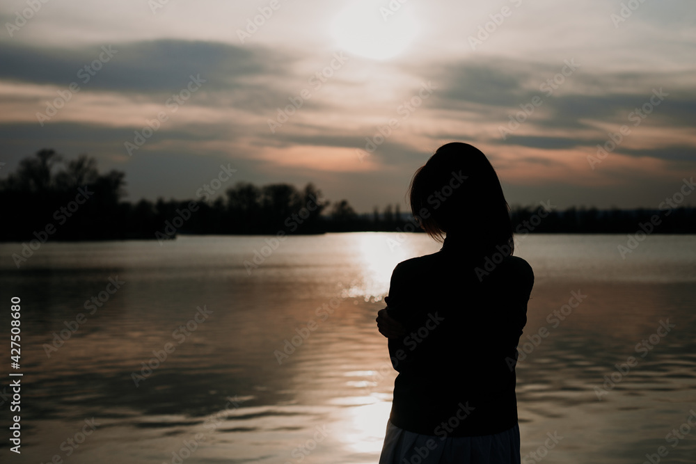 Fototapeta premium woman at sunset enjoys the warm rays