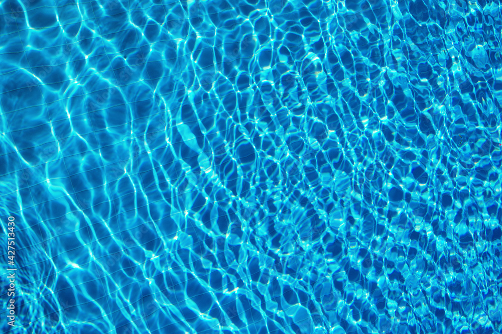 Blue water in swimming pool with sun reflection
