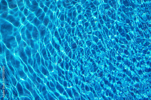 Blue water in swimming pool with sun reflection