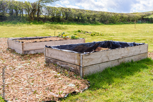 Fényképezés Gardener making a start with raised beds with one full, and one being filled wit