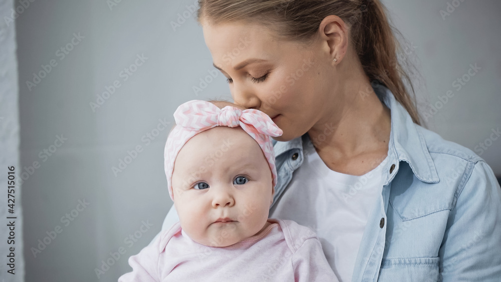 young mother smelling hair of infant daughter. young mother smelling hair of infant daughter.