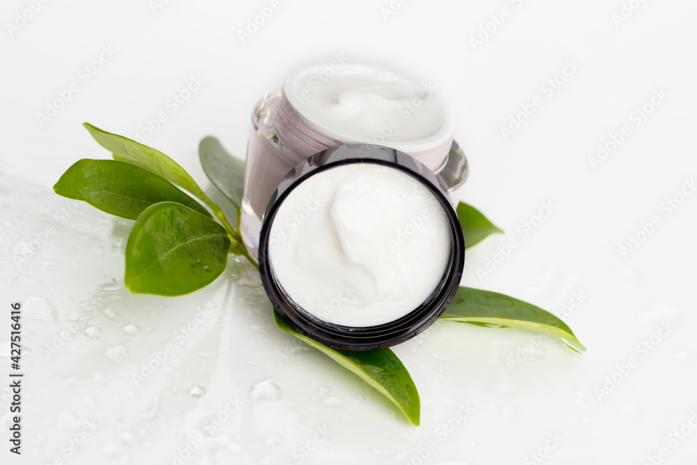 A jar with a cosmetic product on the background of a plant. A jar with a cosmetic product on the background of a plant.
