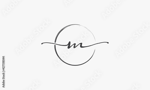 M handwritten logo with circle paint brush design vector. photo