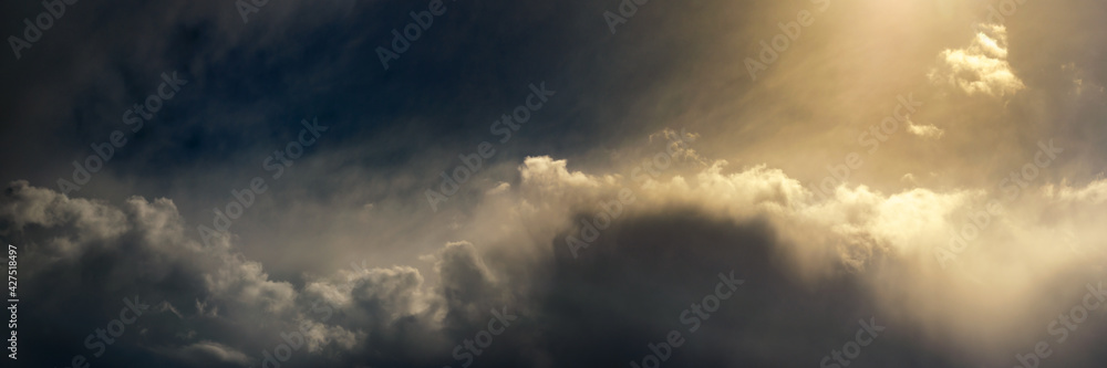 panoramic view of dramatic sky with cumulus clouds and bright sunlight panoramic view of dramatic sky with cumulus clouds and bright sunlight