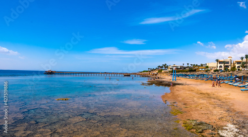 Gorgeous tropic seaside with beatiful transparent sea and sunbeds