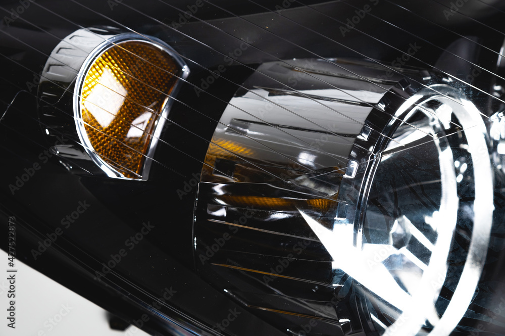 Close-up of a new headlight for a passenger car in soft focus. Auto lighting theme background