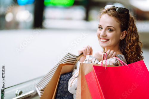 Fashion woman with shopping bags in the mall. Purchases, sale, lifestyle concept. Spring shopping.