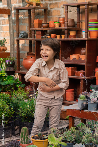Hispanic boy having fun in a greenhouse.