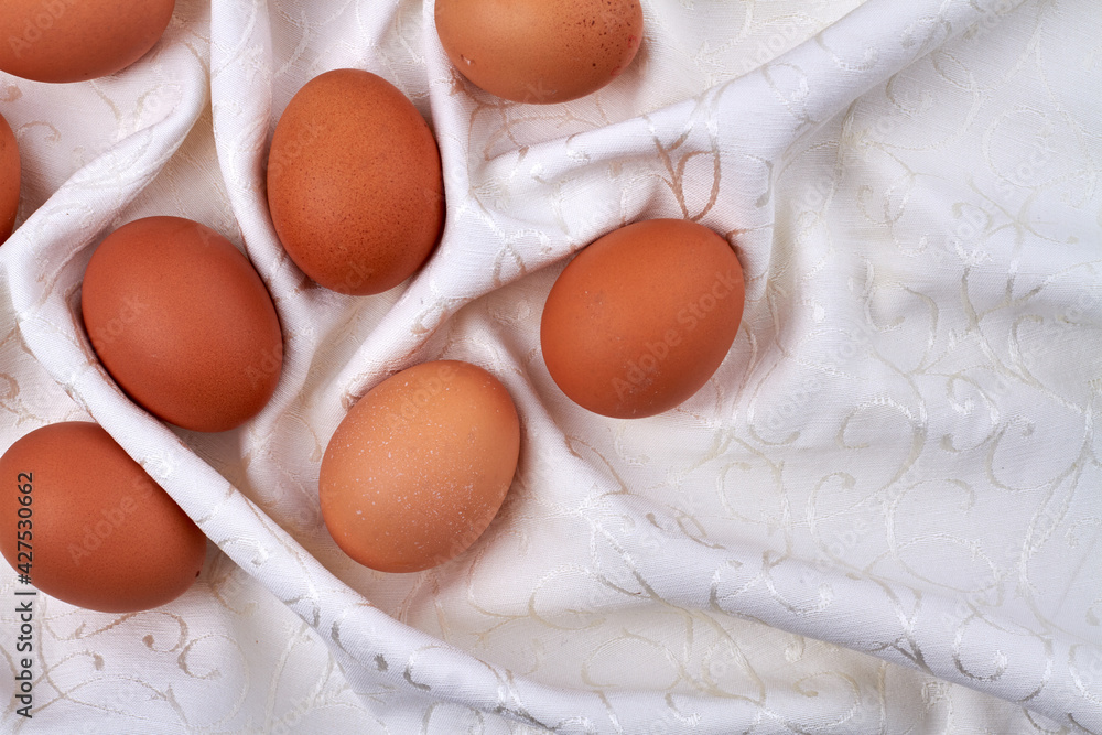 Brown eggs on a white textile cloth. Brown eggs on a white textile cloth.
