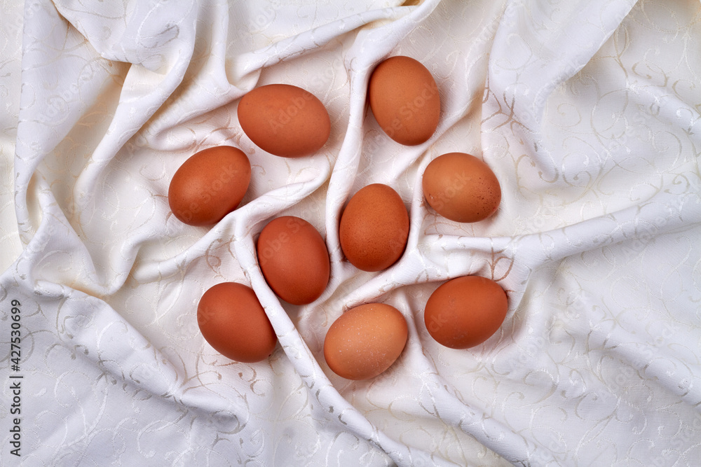 Top view brown eggs on a wrinkled fabric cloth. Top view brown eggs on a wrinkled fabric cloth.