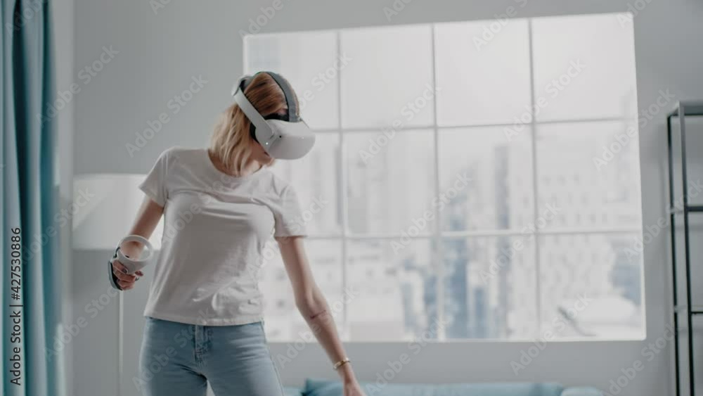 Woman waters flowers playing videogame with VR headset Woman waters flowers playing videogame with VR headset