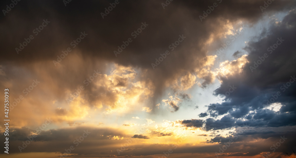 Sunset sky background. Beautiful sunset after rain, with bright orange dramatic clouds.