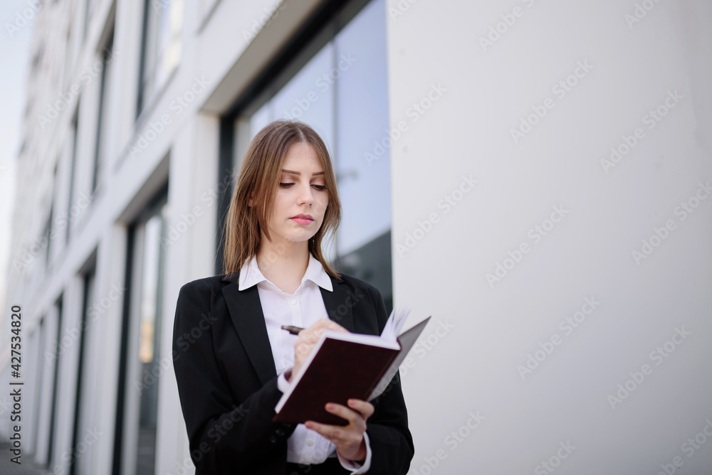 A businesswoman makes a note in a notebook A businesswoman makes a note in a notebook