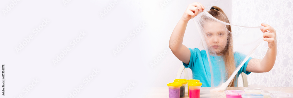A blonde child is playing with a slime. Little beautiful caucasian girl is playing with many slimes. Play Slime Toy A blonde child is playing with a slime. Little beautiful caucasian girl is playing with many slimes. Play Slime Toy