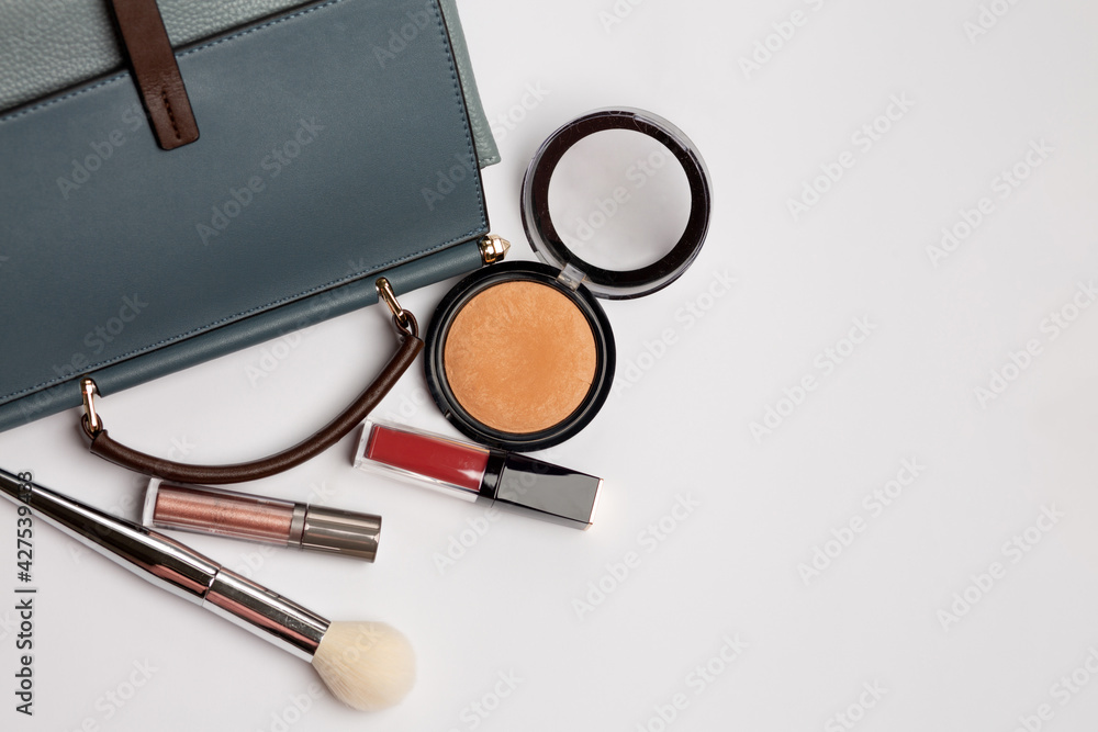 Blue female bag with bronzer, red lipstick and brush Blue female bag with bronzer, red lipstick and brush