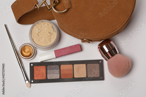 Female purse with baking powder and eye shadow palette
