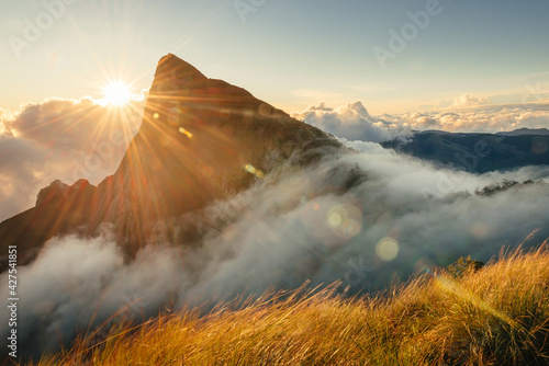 Munnar mountain landscape with flowing fog and clouds at sunrise