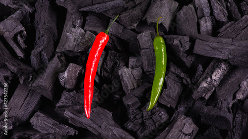 Red hot pepper on a black background, black charcoal. Sharp and dark. Low key. Selective focus