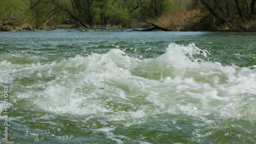 Static shot of fast stream of water and rapids in wetlands branches of Danube river in spring season. Protected nature area in Slovakia. 