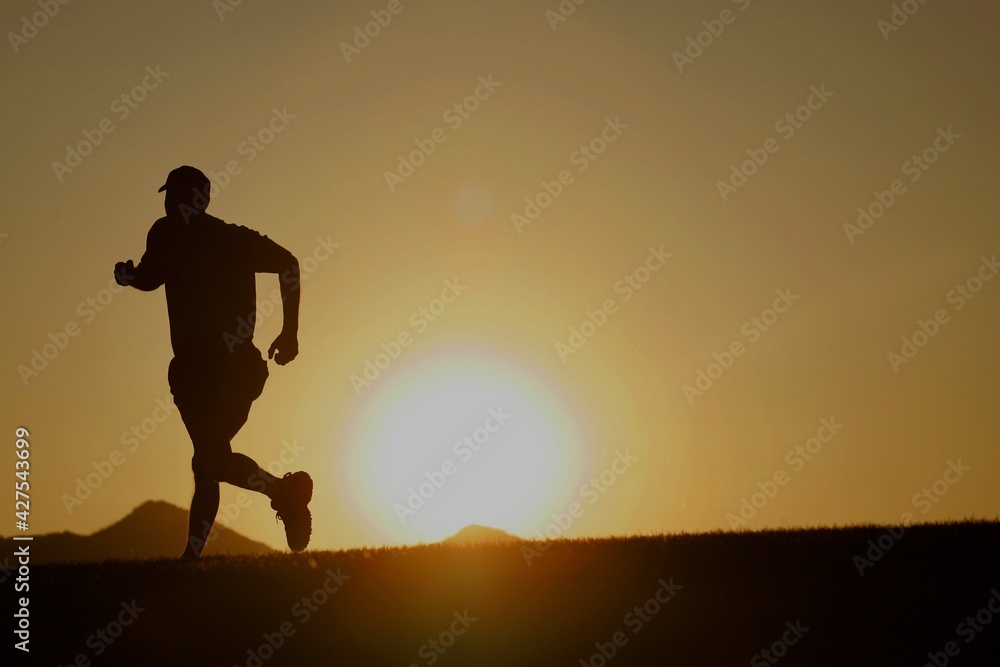 Silhouette of a male runner at sunset