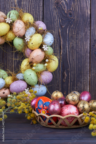 Colored easter eggs and yellow willow branch.