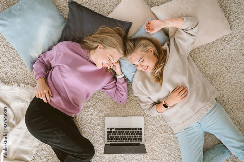 Mom with daughter watching series on laptop at home. Family entertainment and spending time together and self-isolation concept.