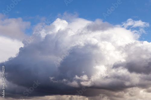 Storm sky. Dark grey big cumulus clouds against blue sky background, cloud texture, thunderstorm © Viktor Iden