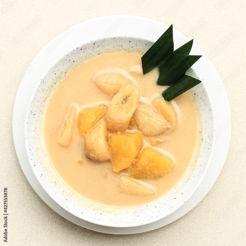 Top View Kolak Pisang Ubi or Banana and Sweet Potato Compote is Popular Indonesian Dessert made from Banana Sweet Potato Cooked with Coconut Milk, Palm Sugar, and Pandan Leaves. Popular during Ramadan Top View Kolak Pisang Ubi or Banana and Sweet Potato Compote is Popular Indonesian Dessert made from Banana Sweet Potato Cooked with Coconut Milk, Palm Sugar, and Pandan Leaves. Popular during Ramadan