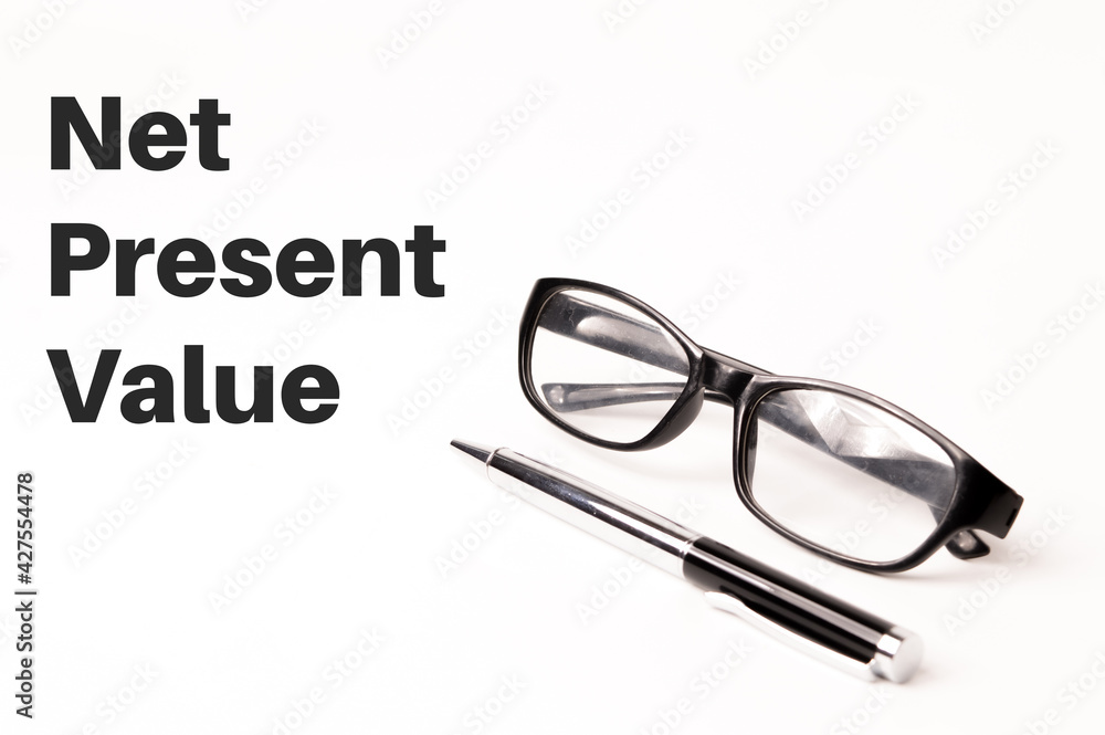 Pen, eyeglasses over white background written with NET PRESENT VALUE. Business and financial concept. Pen, eyeglasses over white background written with NET PRESENT VALUE. Business and financial concept.