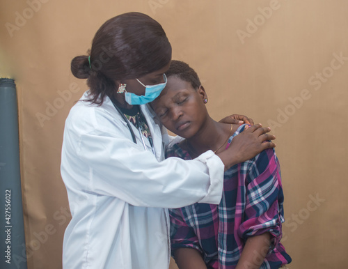 African female nurse , doctor or medical specialist checking , consoling and encouraging a lady patient for health reasons, and also has stethoscope with her 