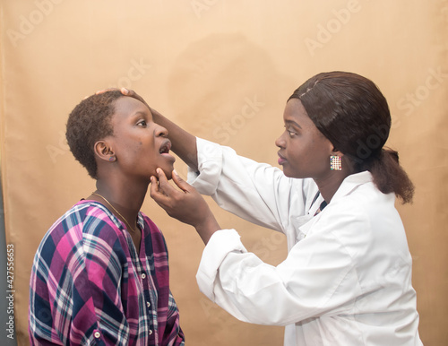 African female nurse , doctor or medical specialist checking a lady patient for health reasons, and also has stethoscope with her 