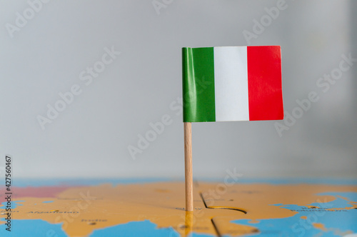 Small flag of Ital on a wooden stick fixed on the globe photo