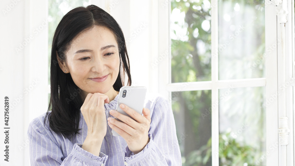 スマホを操作するミドル女性 スマホを操作するミドル女性