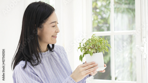 家で観葉植物を育てるミドル女性