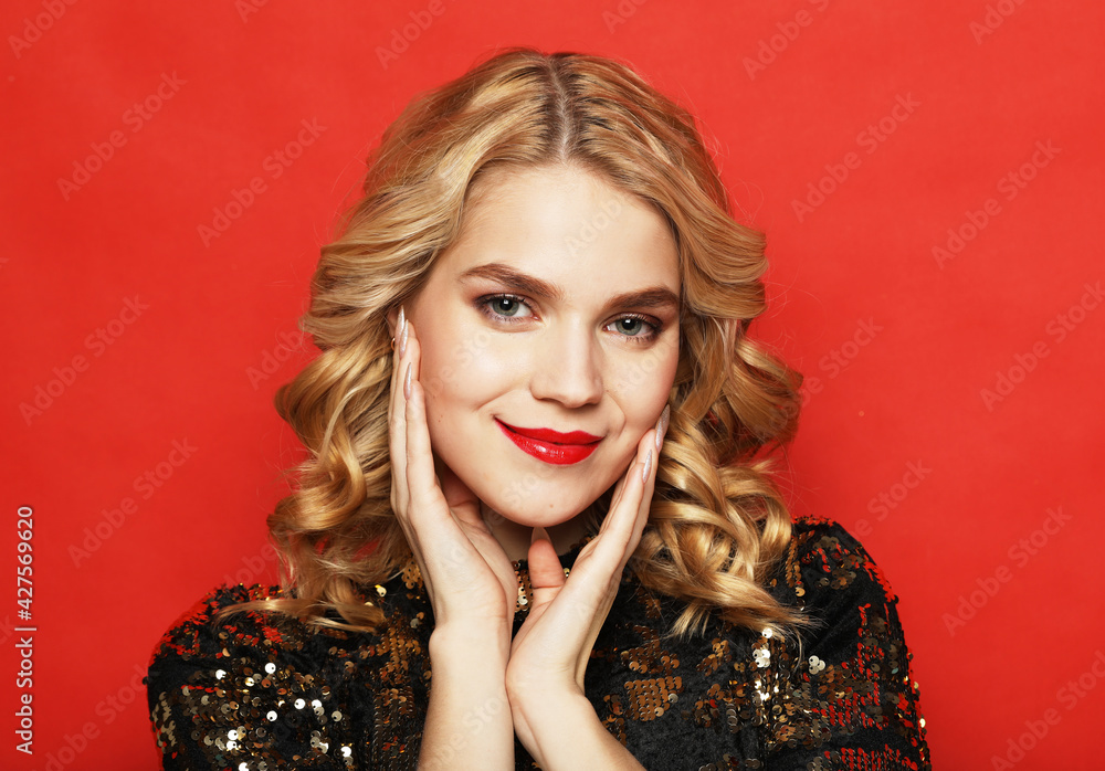 lifestyle, party and people concept - Gorgeous blonde woman in an evening dress flirty and playful on a red background lifestyle, party and people concept - Gorgeous blonde woman in an evening dress flirty and playful on a red background