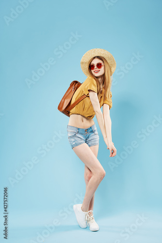 Pretty woman student with backpack fashionable clothes blue background