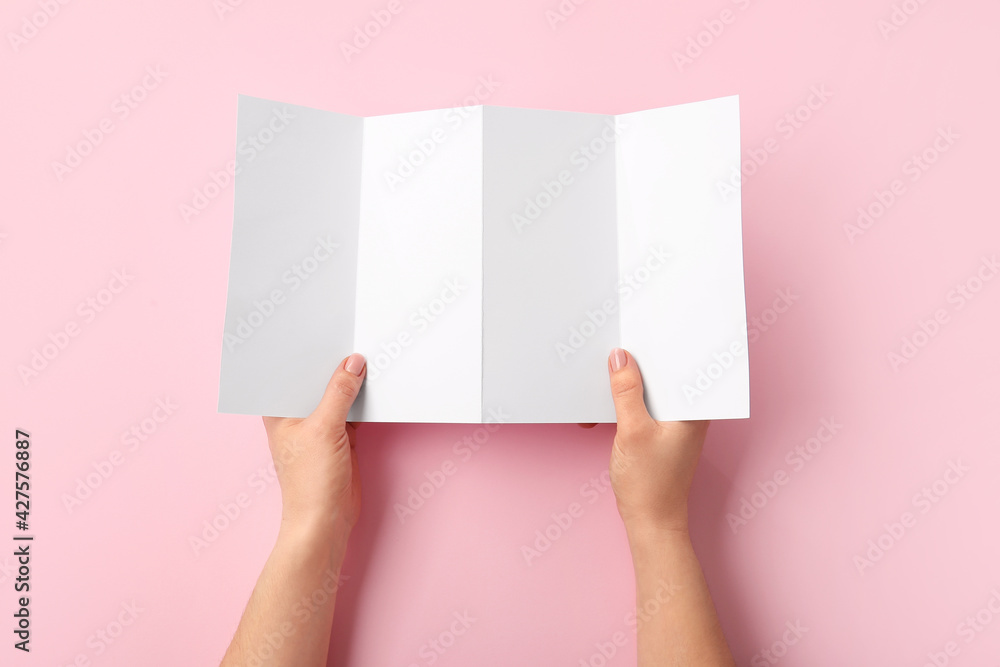 Hands with blank brochure on color background Hands with blank brochure on color background