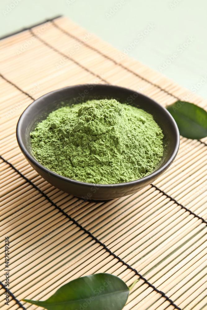 Bowl with powdered matcha tea on bamboo mat Bowl with powdered matcha tea on bamboo mat