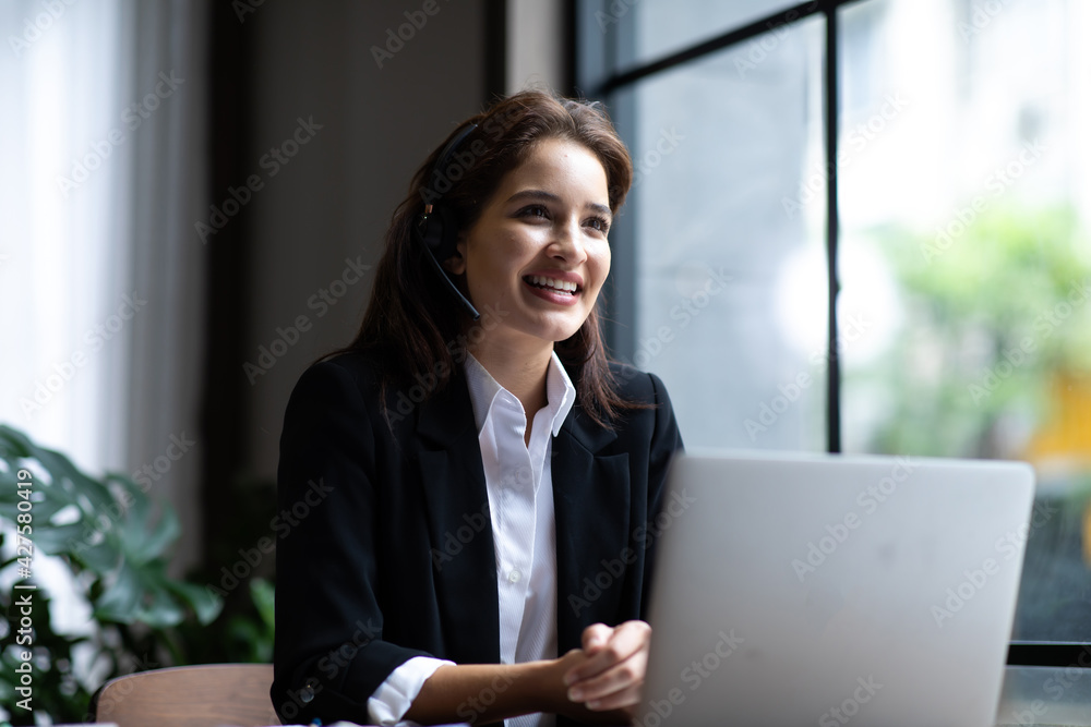 Attractive business woman Asian in suits and headsets are smiling while working with computer at office. Customer service assistant working in office. VOIP Helpdesk headset Attractive business woman Asian in suits and headsets are smiling while working with computer at office. Customer service assistant working in office. VOIP Helpdesk headset