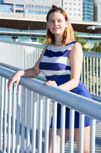 Portrait of young stylish girl posing on city bridge in summer day © JackF
