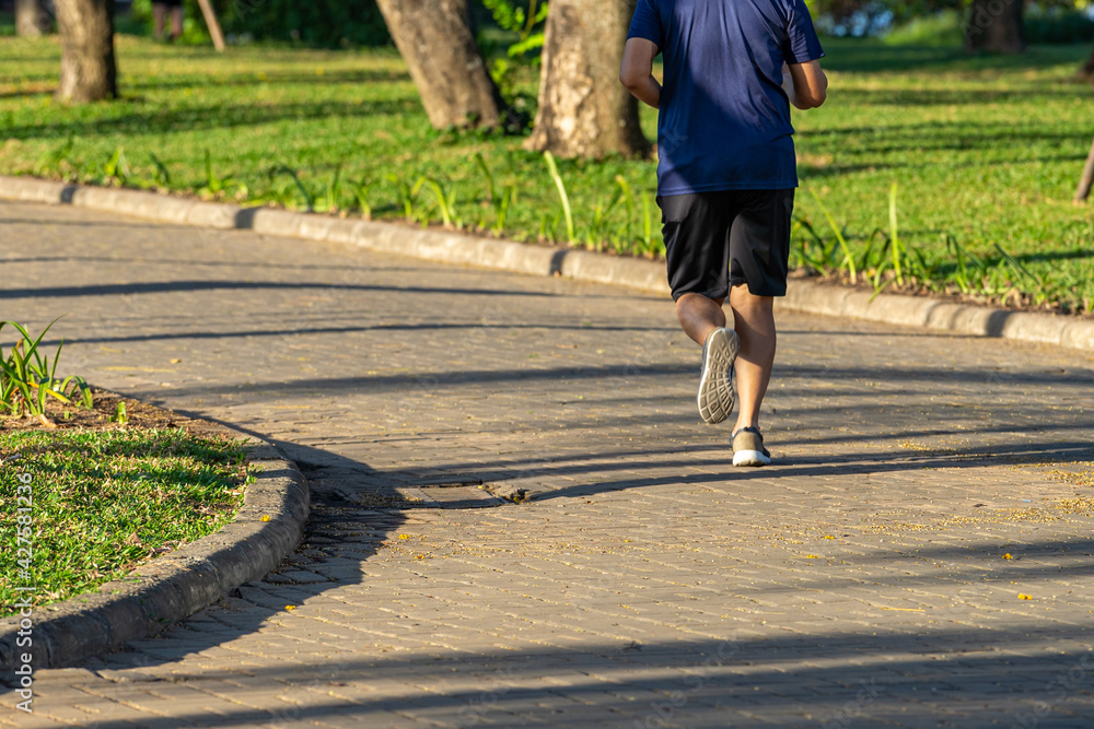 Fototapeta premium Young man running in the park in a sunny day