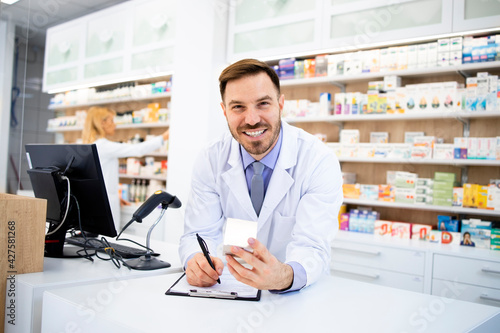 Pharmacist selling medicines in pharmacy store.