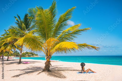Caribbean travel summer vacation woman sunbathing on beach during cruise holiday. Luxury getaway on Dover Beach resort, Barbados island.