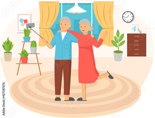 Elderly couple standing with monopod against background of window and making photo together on phone